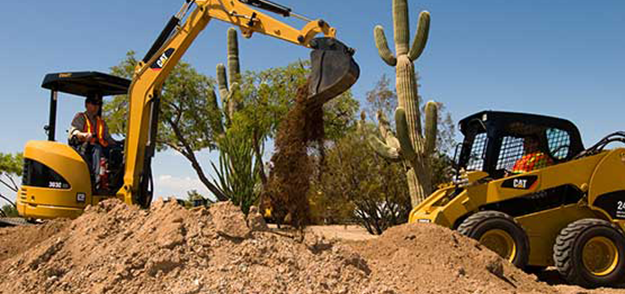 mini excavator digging up mounds of dirt