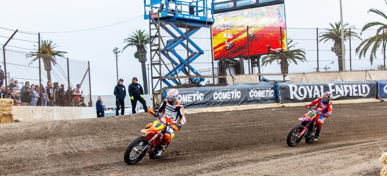 Bikes on a dirt track with scissor lift in background
