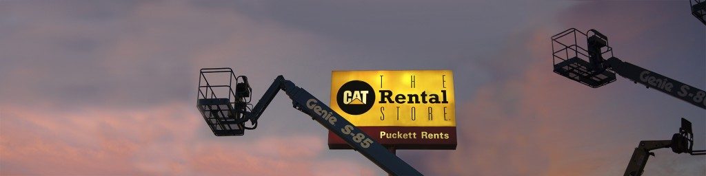 The Cat Rental Store Puckett Rents Sign in the evening with Boom Lifts